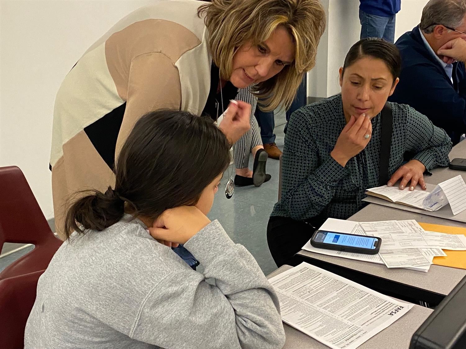 Counselor helping a female student fill out the Free Application for Federal Student Aid.